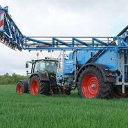 Niebieski opryskiwacz polowy zaczepiany firmy lemken typ Albatros pracujący na polu z ciągnikiem rolniczym Korbanek.pl