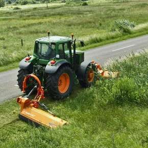Zielony traktor rolniczy z podczepionym zestawem kosiarek bijakowych firmy Samasz kosi pobocze drogi www.korbanek.pl