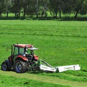 Czerwony traktor kosi trawę kosiarką dyskową KDT 260 firmy Samasz www.korbanek.pl