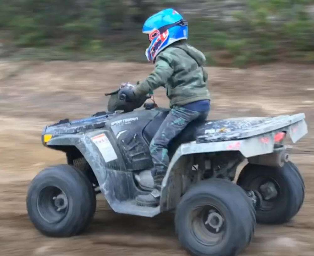 Nauka jazdy quadem Polaris Sportsman 110 - dziecko i instruktor NAuka jazdy quadem Sportsman 110 Polaris kolor niebieski - dziecko w kaski i instruktor podczas nauki
