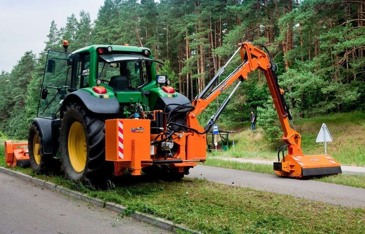Kosiarka bijakowa wysięgnikowa SAMASZ KWT 650 Kosiarka bijakowa wysięgnikowa KWT 650 zawieszona na zielonym ciągniku Ramiona wysięgnikowe korbanek.pl